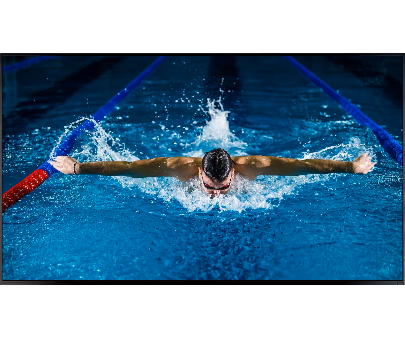 Swimmer doing butterfly stroke in a pool with arms extended and water splashing.