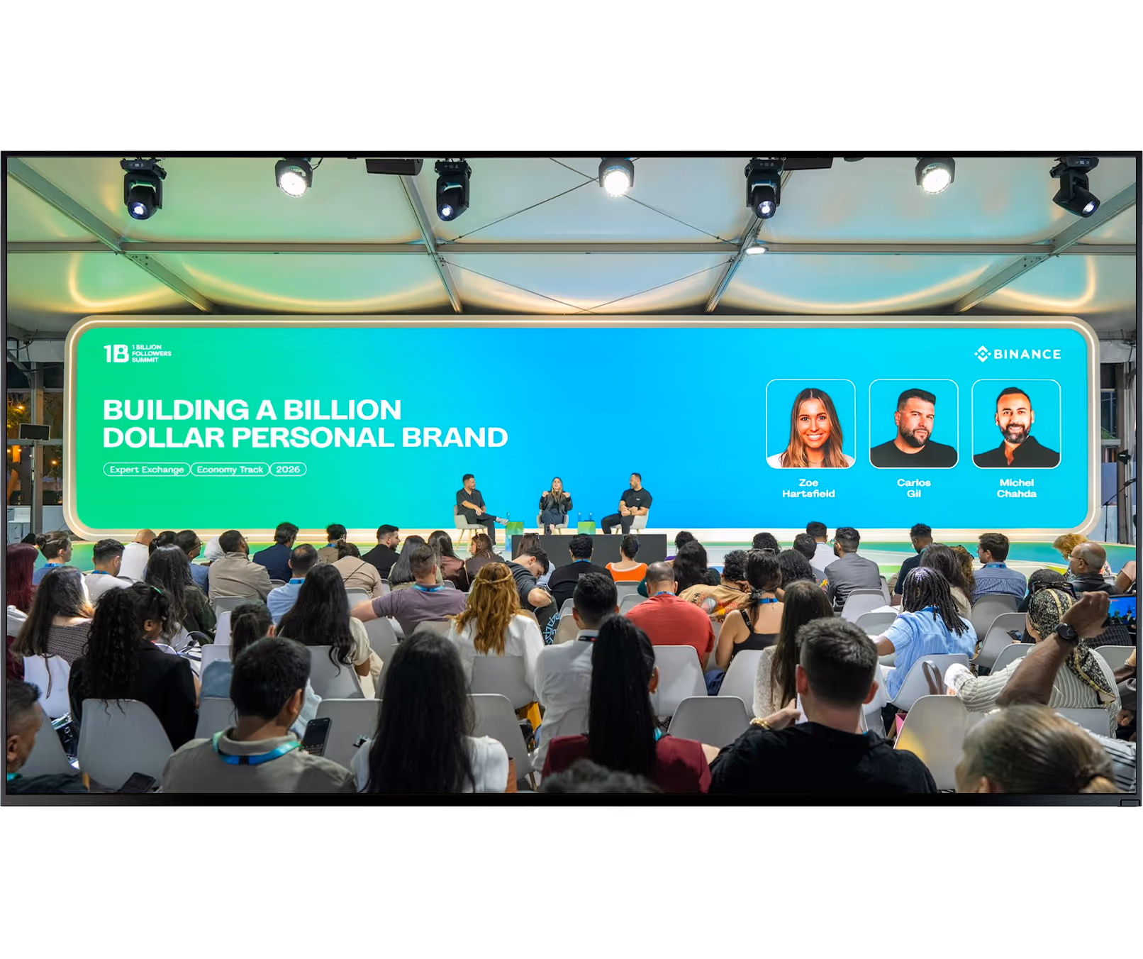 Audience watching panel discussion titled Building a Billion Dollar Personal Brand with three speakers on stage.