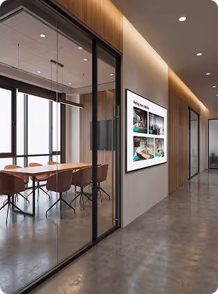 Modern office hallway with glass-walled meeting room and wooden paneling along the corridor.