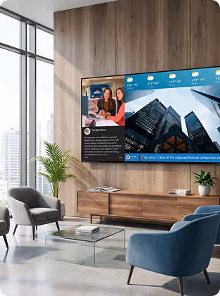 Modern living room with large wall TV displaying news and weather, surrounded by chairs and plants.
