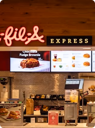 Chick-fil-A Express counter with menu boards showing food items and a chocolate fudge brownie.